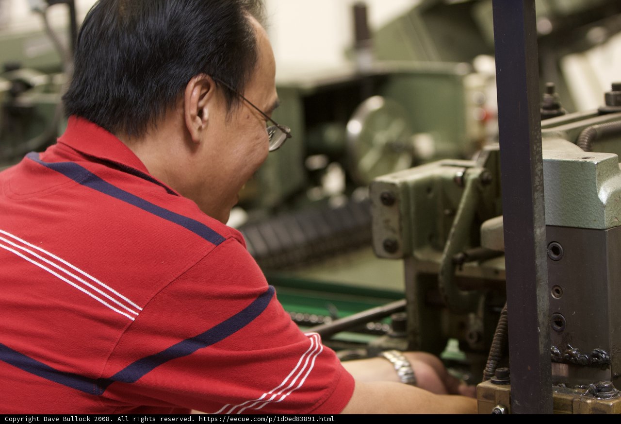 Factory Worker Maintaining a Machine