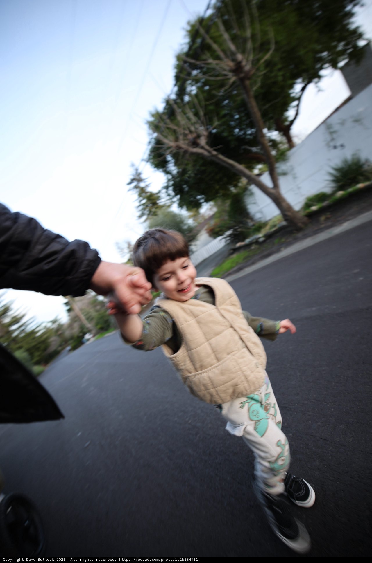 Child Walking Hand-in-Hand on Suburban Street