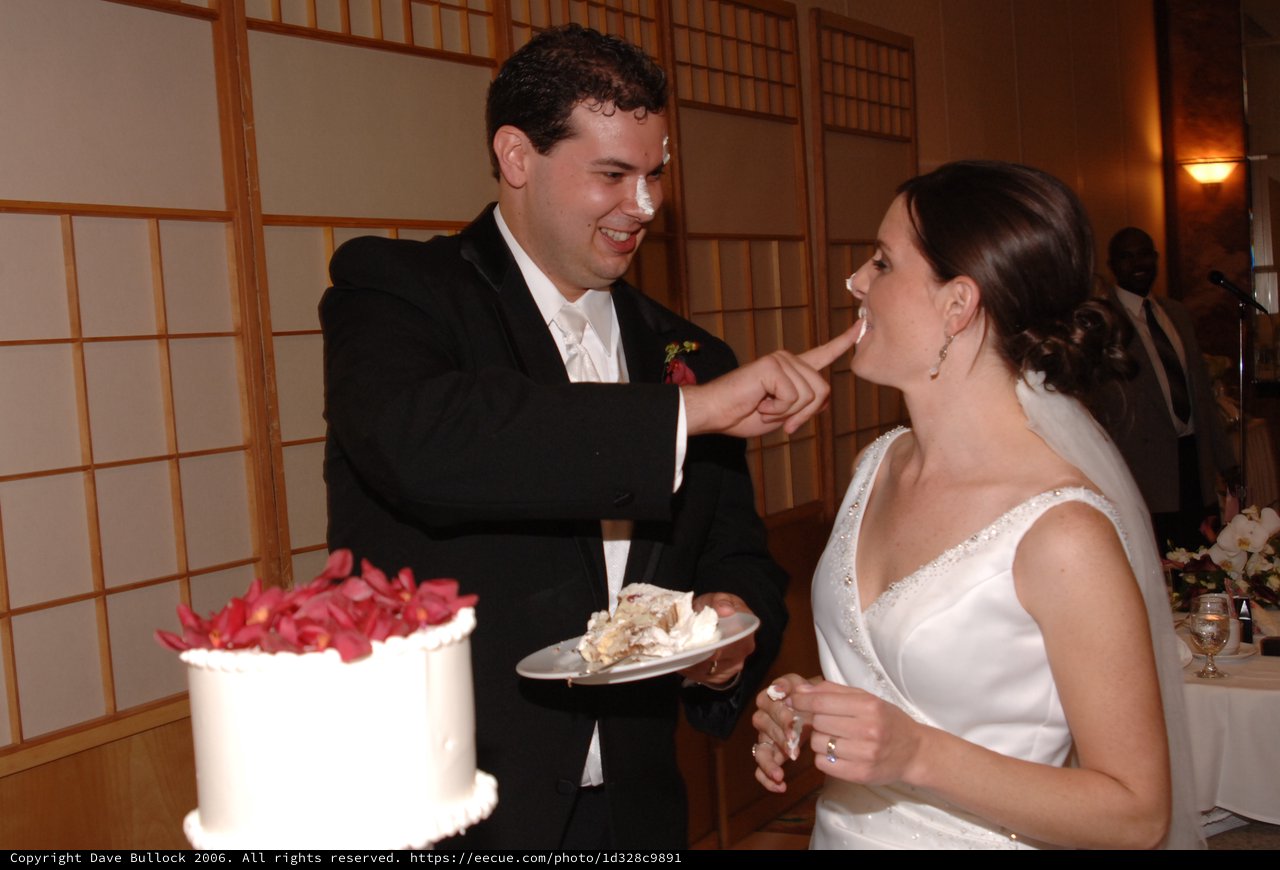 Bride and Groom Share Playful Wedding Cake Moment