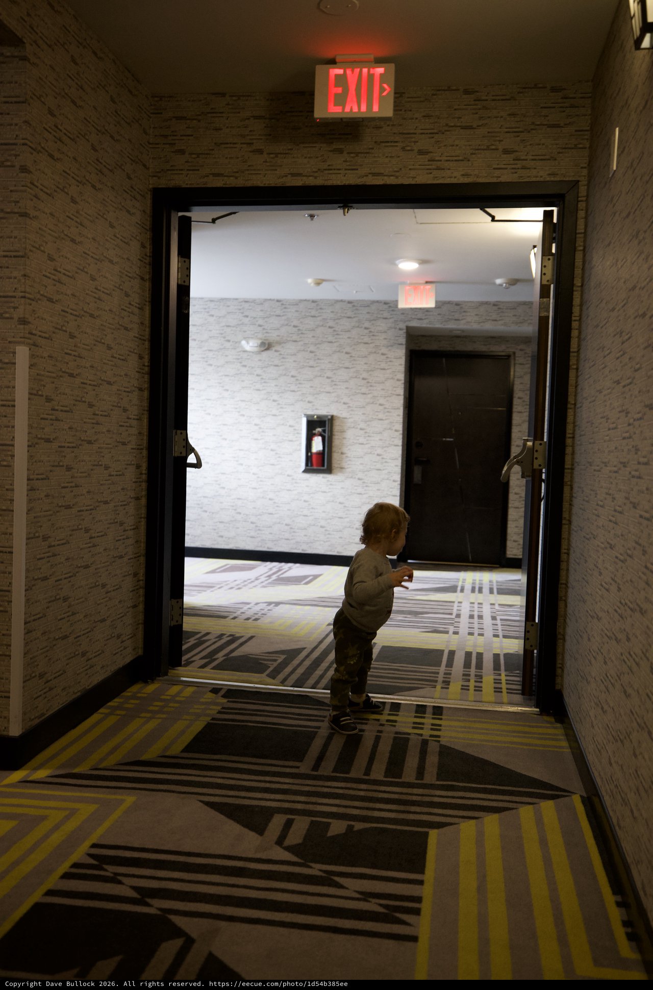 Toddler Exploring Modern Hotel Hallway at Night