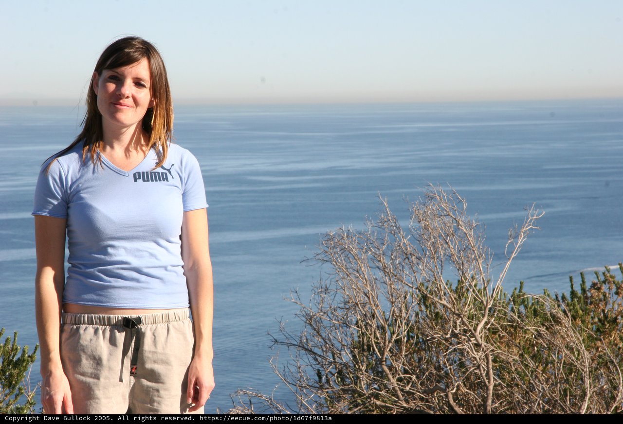 Woman in Puma Shirt Overlooking Coastal Cliffs
