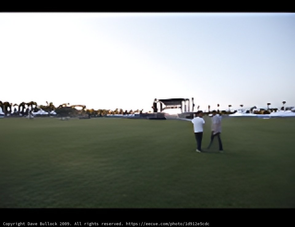Stage and People on Grassy Field