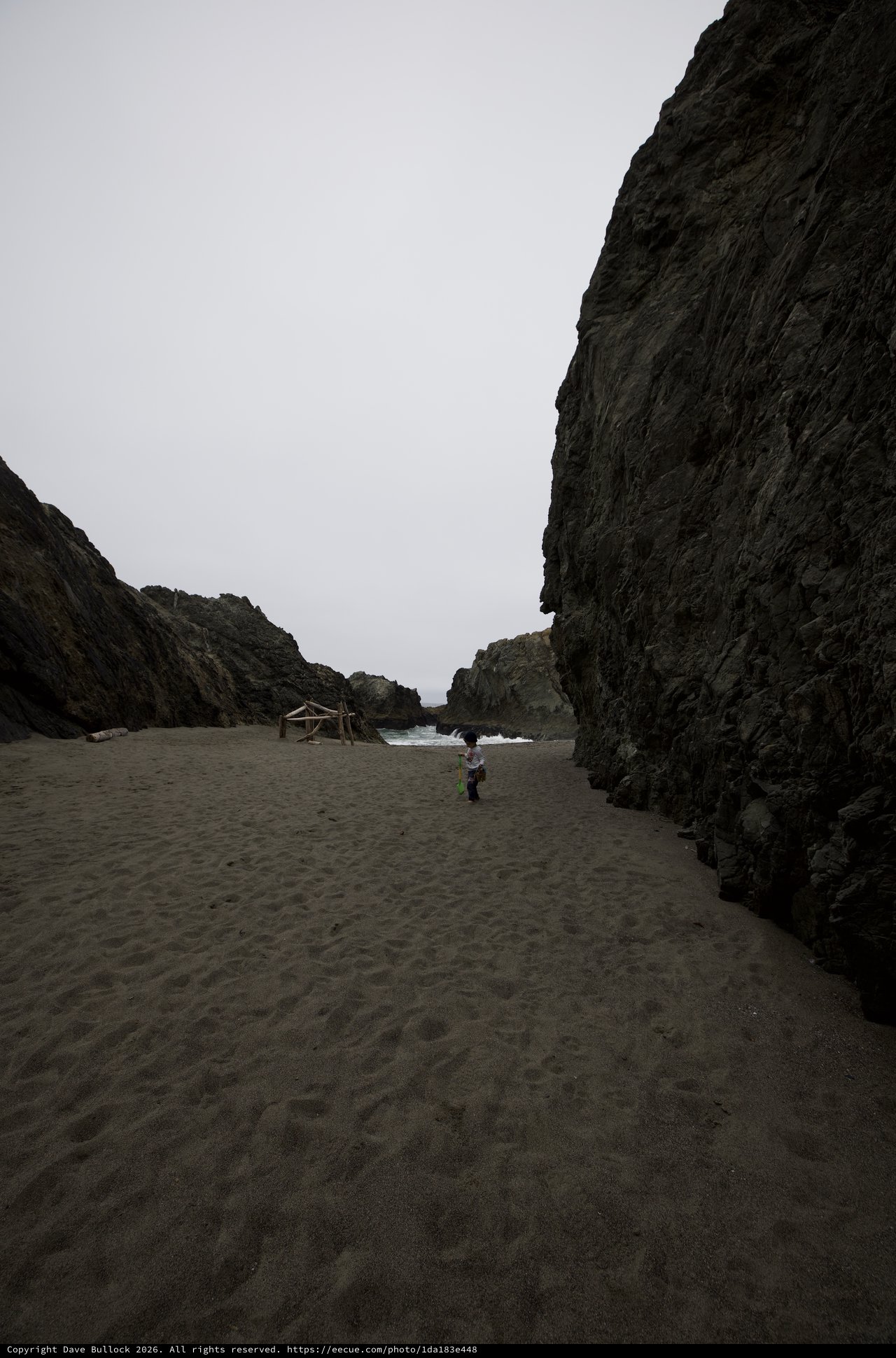 Child Exploring a Dramatic Coastal Cove at Low Tide