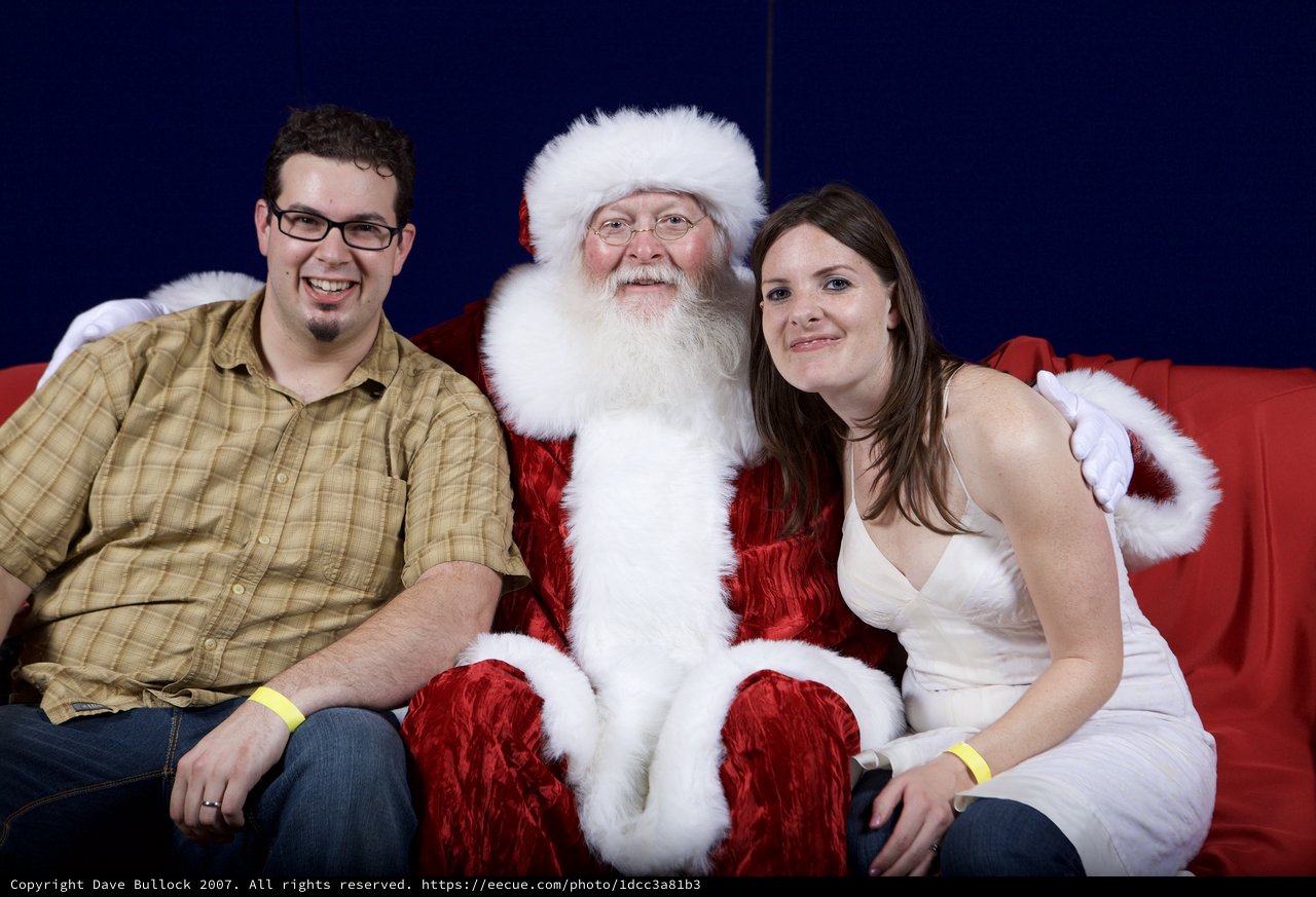 Holiday Couple Poses with Santa Claus Portrait