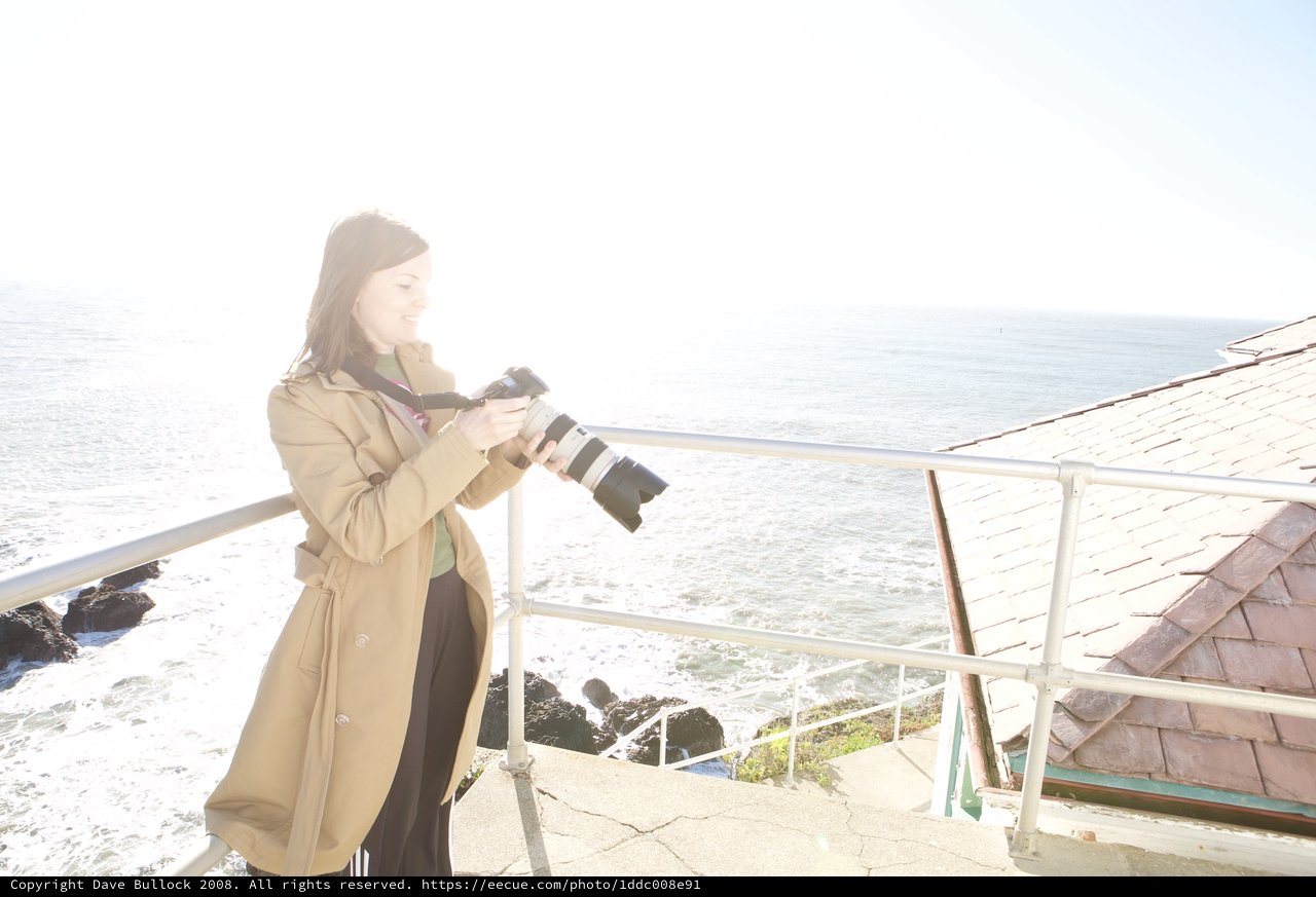 Photographer Capturing Coastal Scenes with Professional Camera