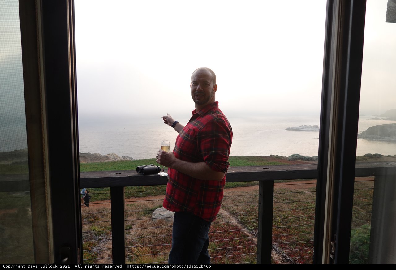 Man enjoying coastal view from balcony