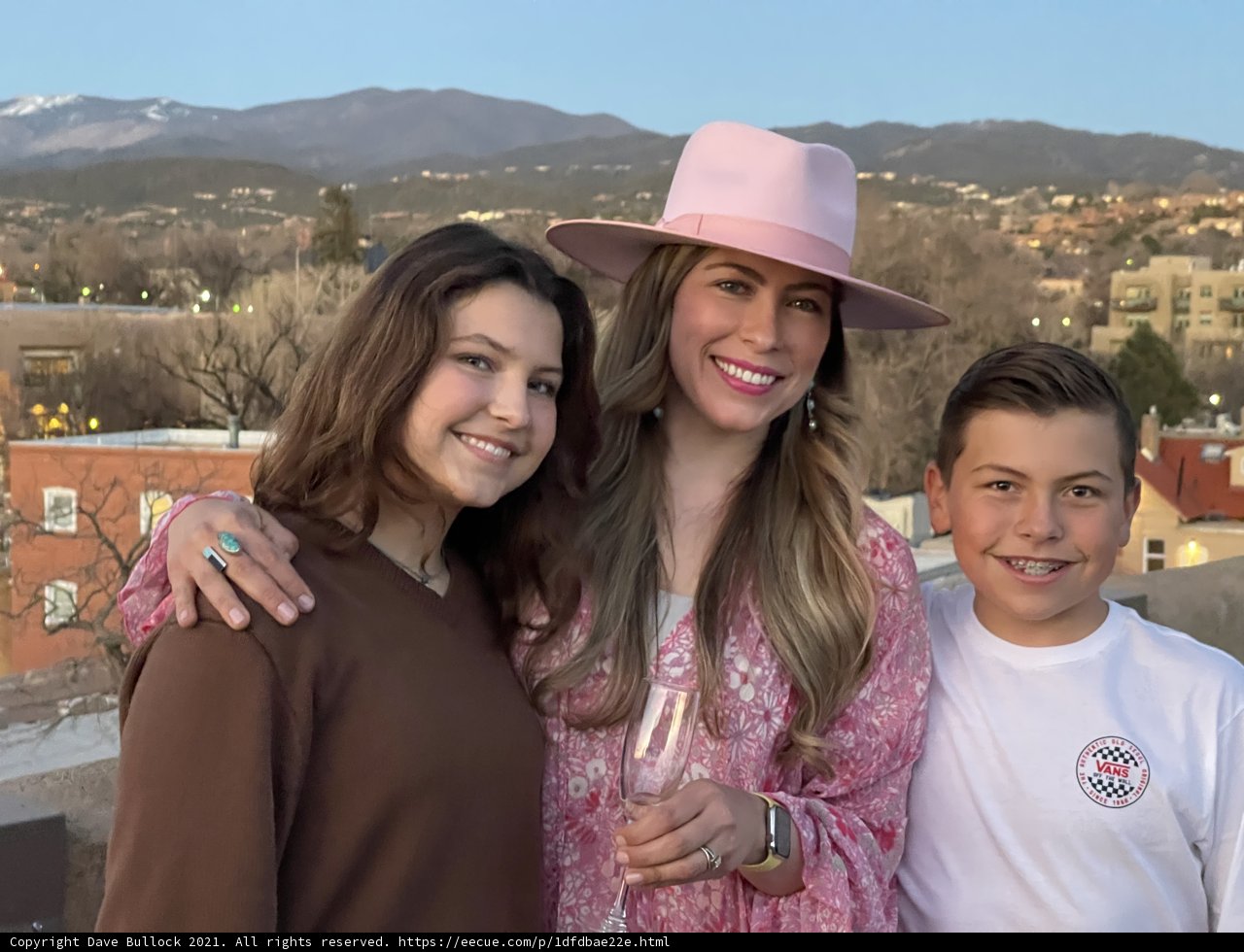 Smiling Trio in Hats Pose Against Blue Sky