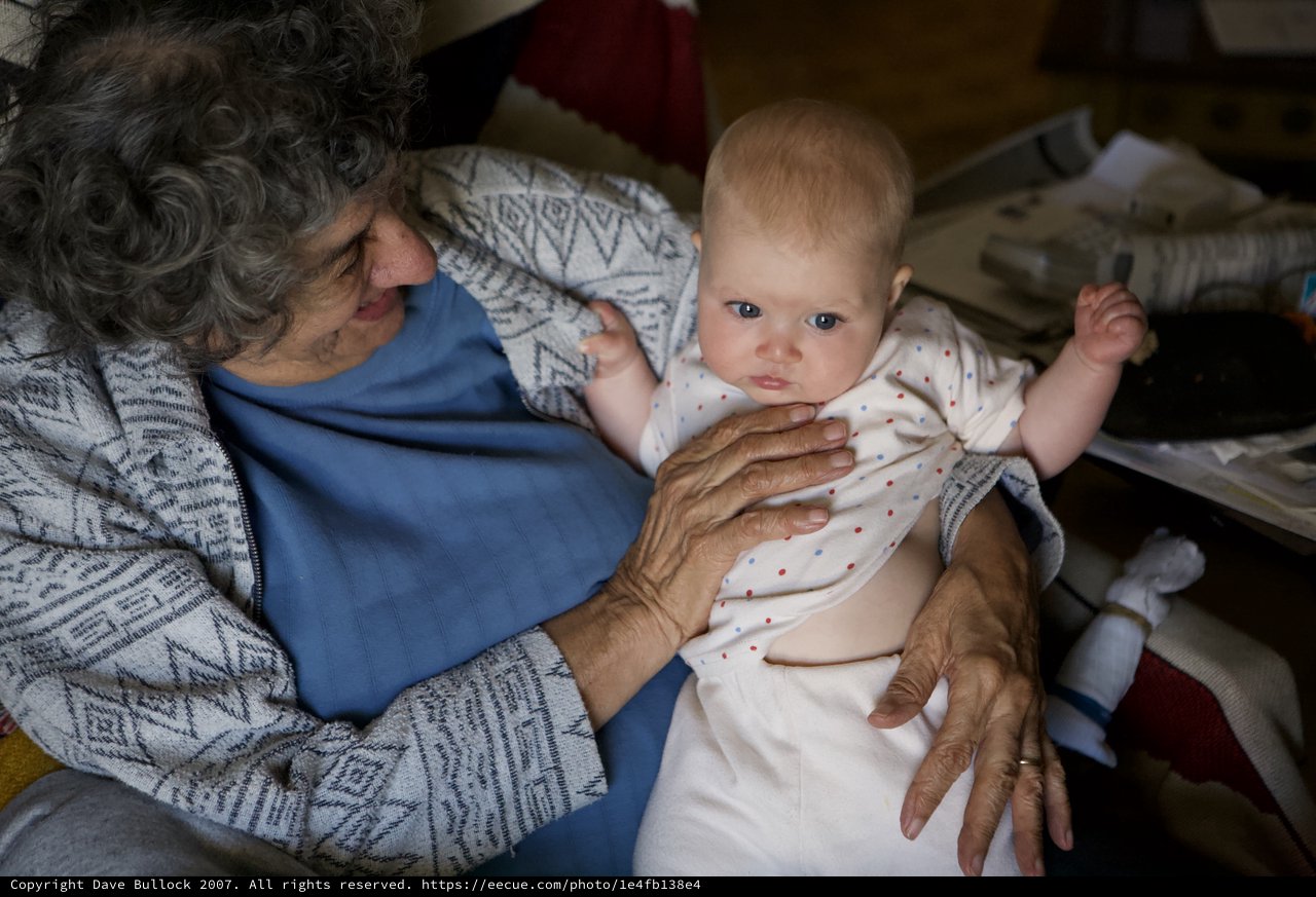 Grandmother's Gentle Embrace with Curious Newborn Baby