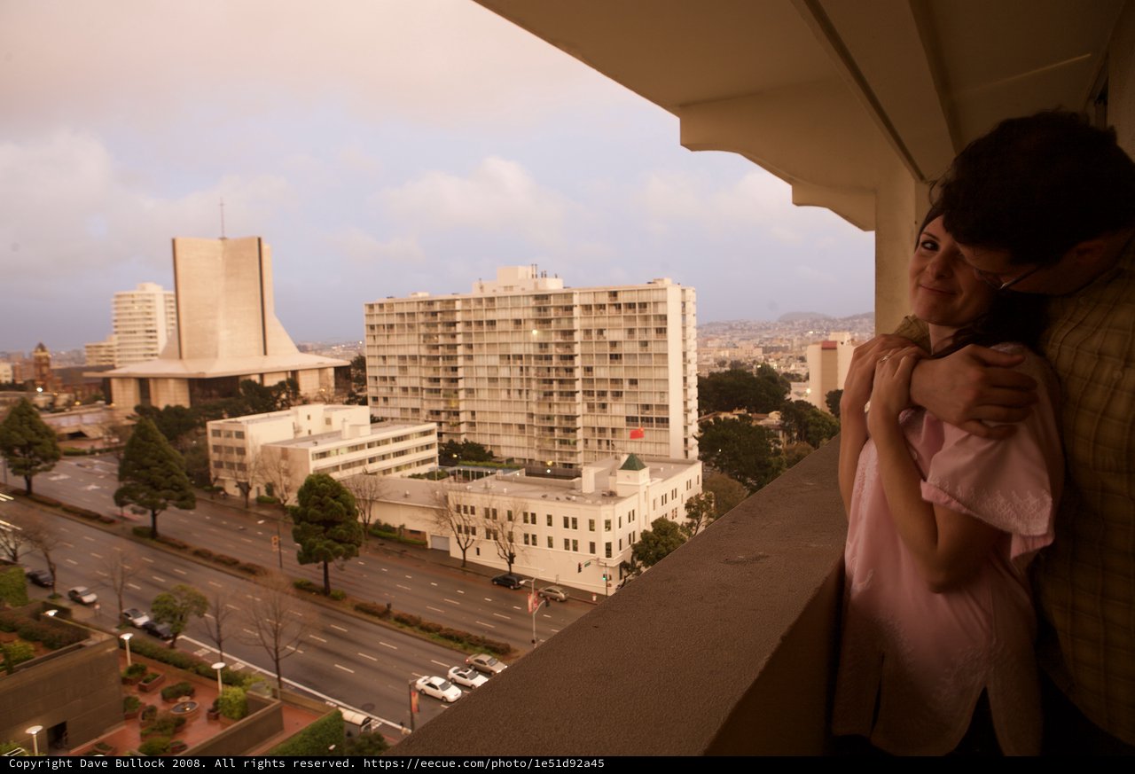 Couple Embracing on Hotel Balcony Overlooking San Francisco