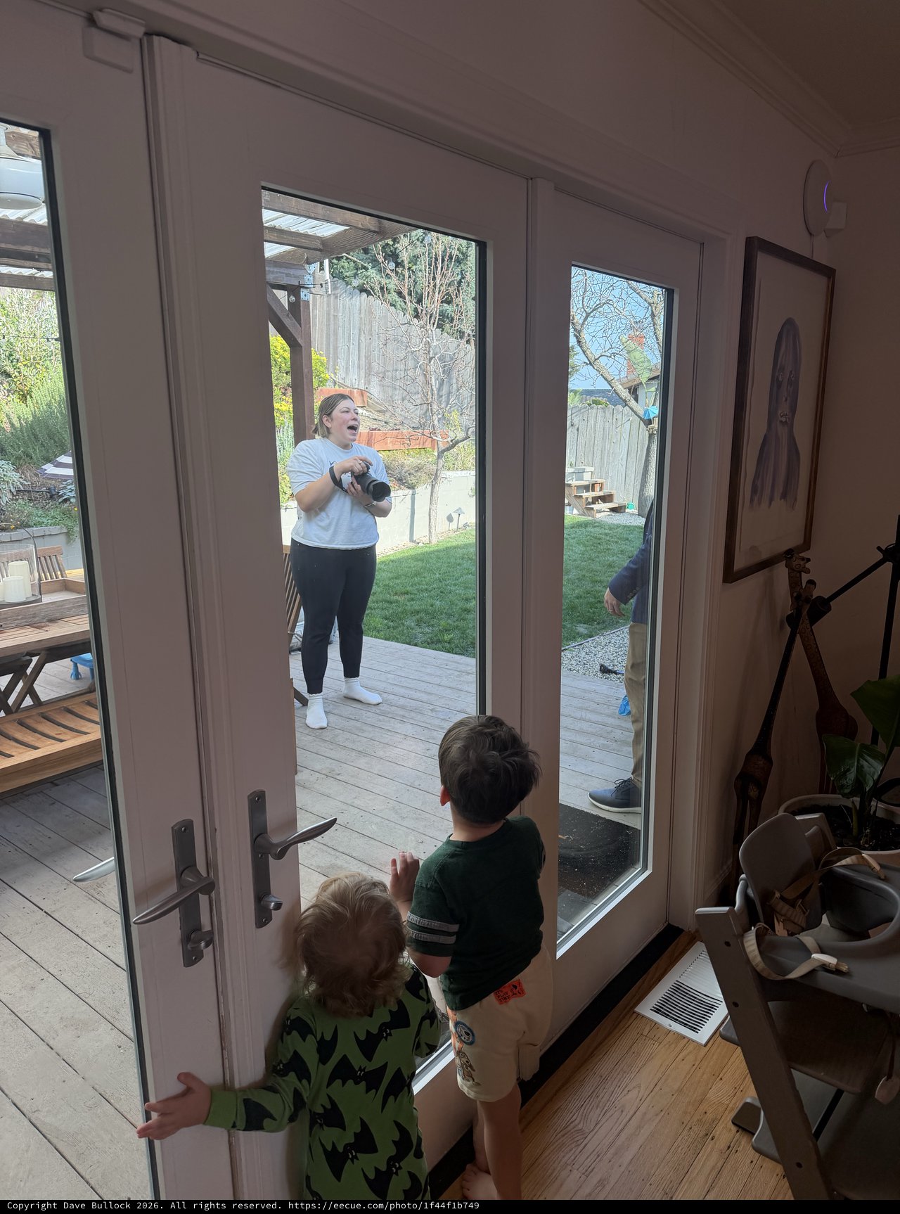 Mother and Children Sharing a Moment Through Glass Door