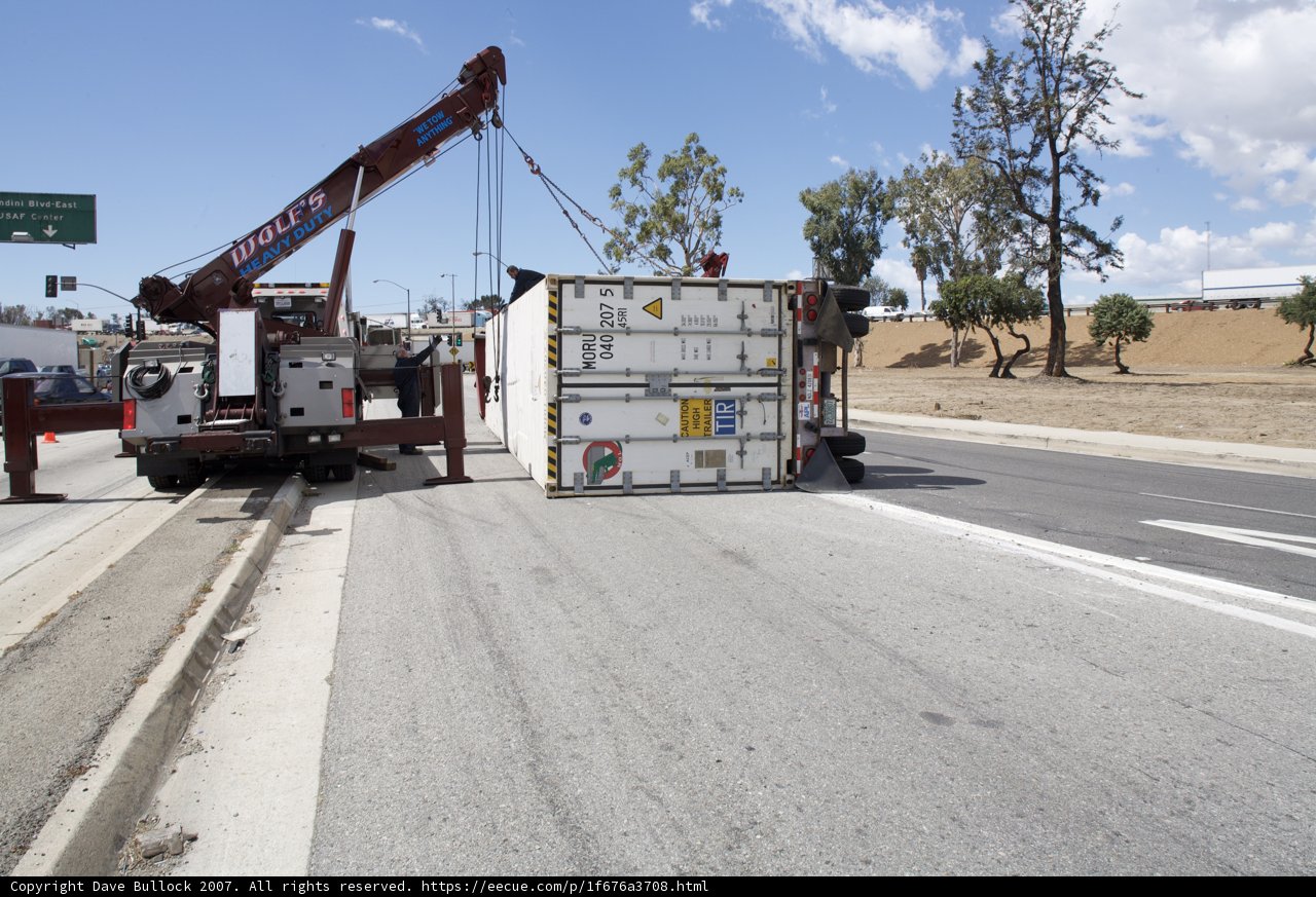 Crane Lifting Shipping Container Onto Truck