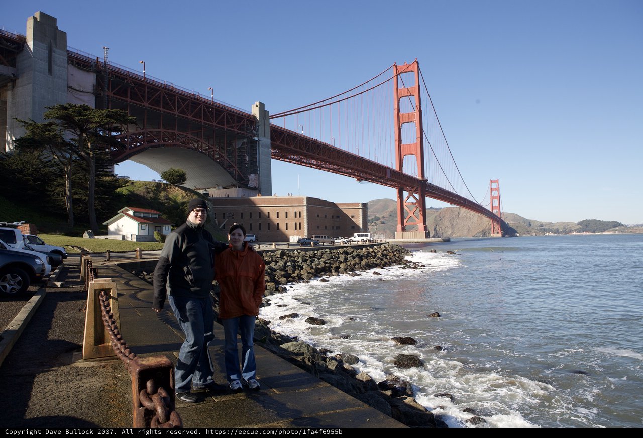 Couple Poses Beneath the Golden Gate Bridge