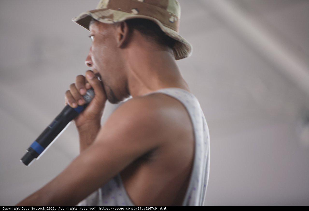 Sam R performs with a microphone and a hat at Coachella 2011