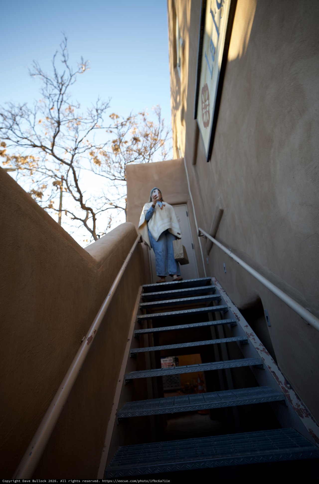 Upward Perspective: Woman at Top of Metal Staircase