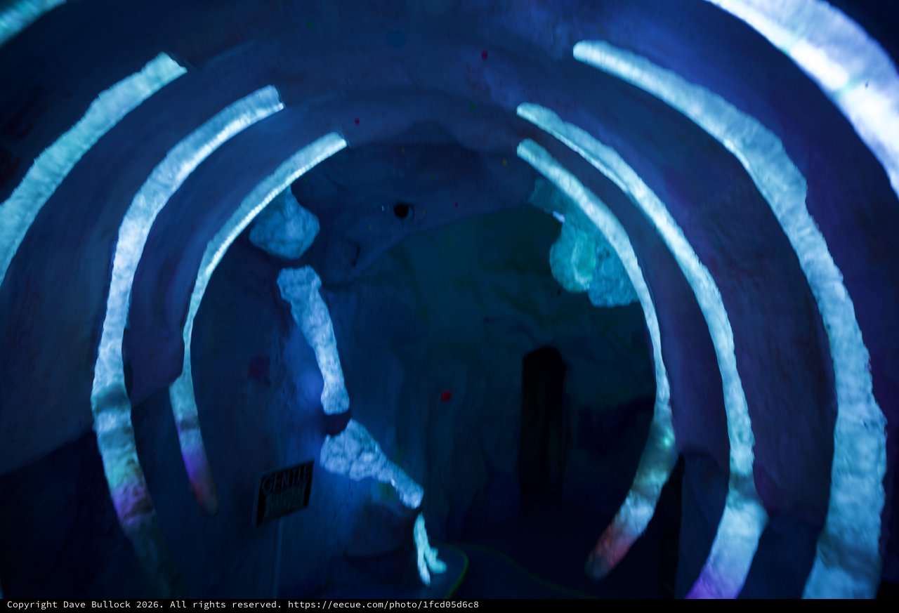 Immersive Blue Spiral Light Installation with Silhouettes