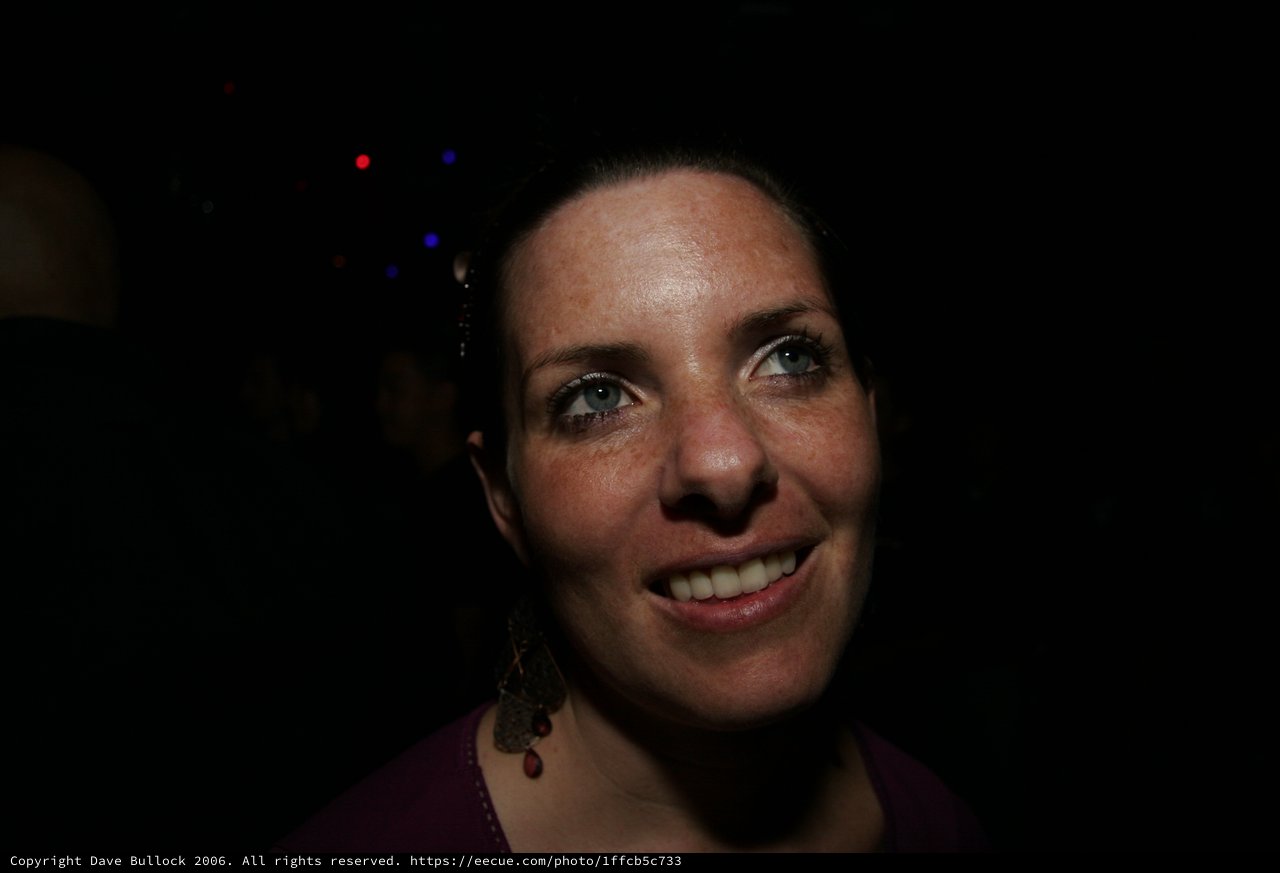 Smiling Woman in Dimly Lit Event Venue