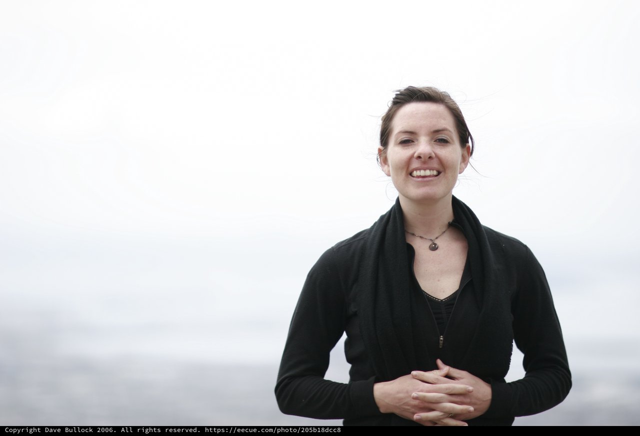 Smiling Woman Portrait Against Misty Ocean Backdrop