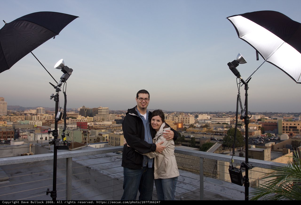 Couple Embraces on Rooftop Overlooking Los Angeles Skyline
