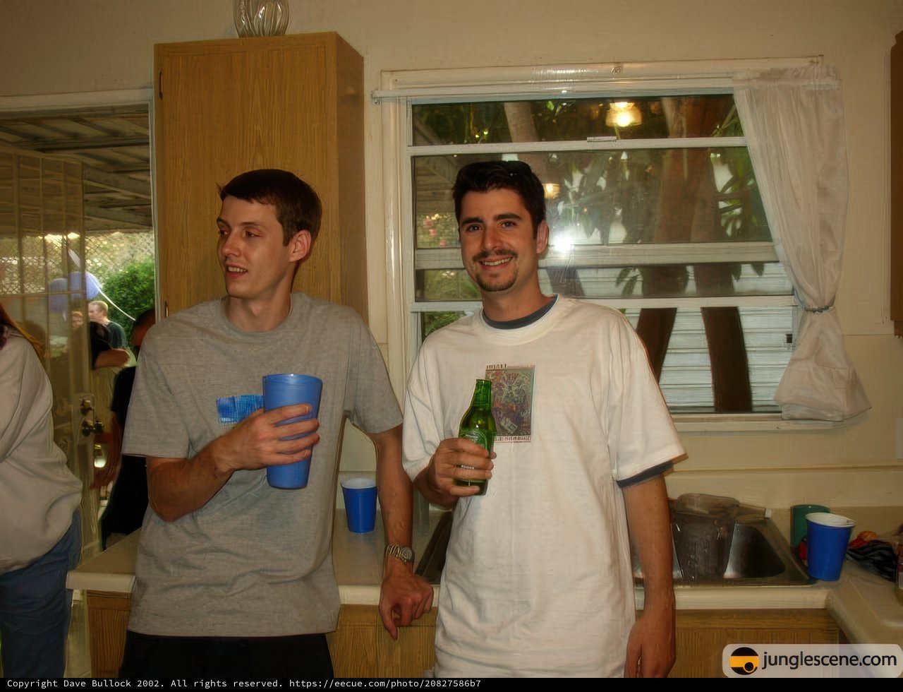 Two Men Enjoying Drinks in the Kitchen