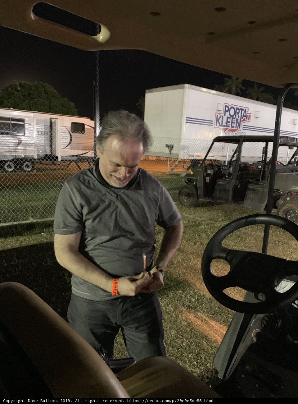 Man checking his phone in a golf cart