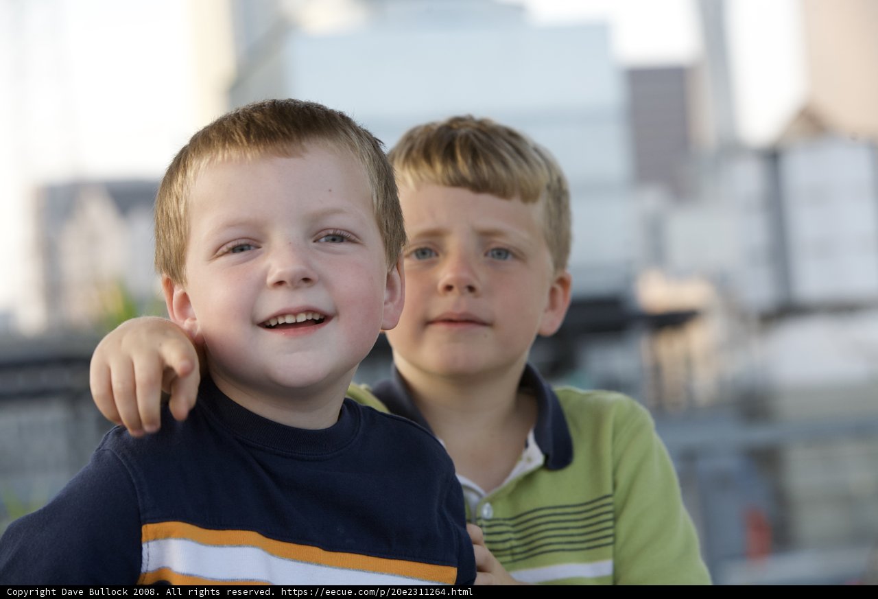 Two Boys Grinning with City Skyline