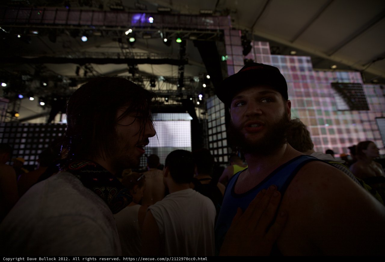 Two Men Enjoying Drinks at a Spotlighted Bar
