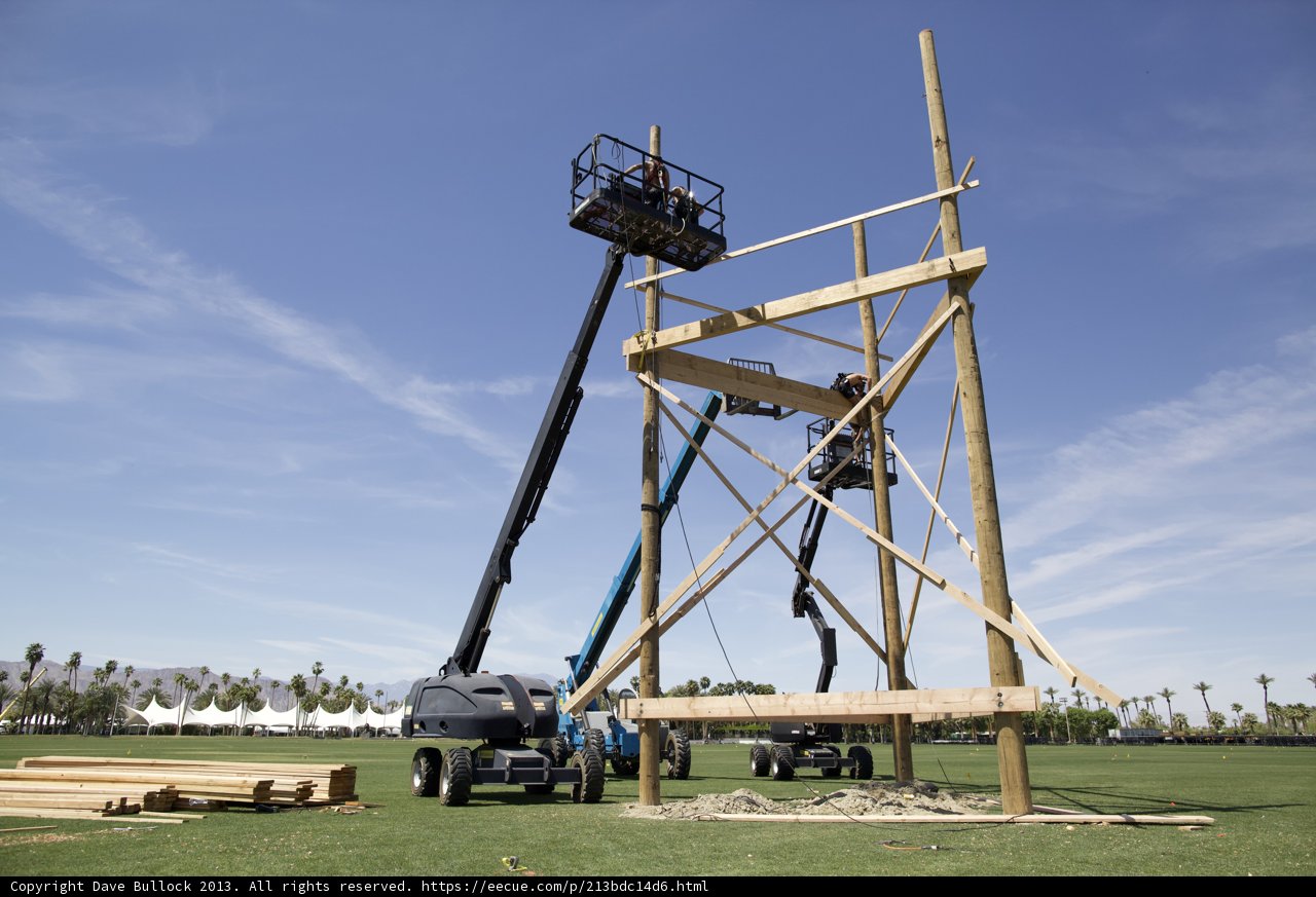Construction Crane Hoists Wooden Structure on Field