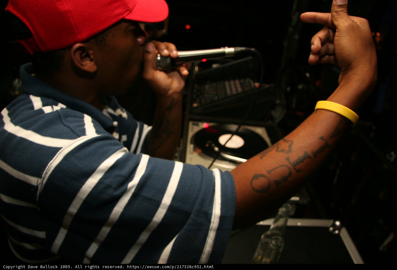 Blue Shirted Entertainer with Tattoos and a Mic