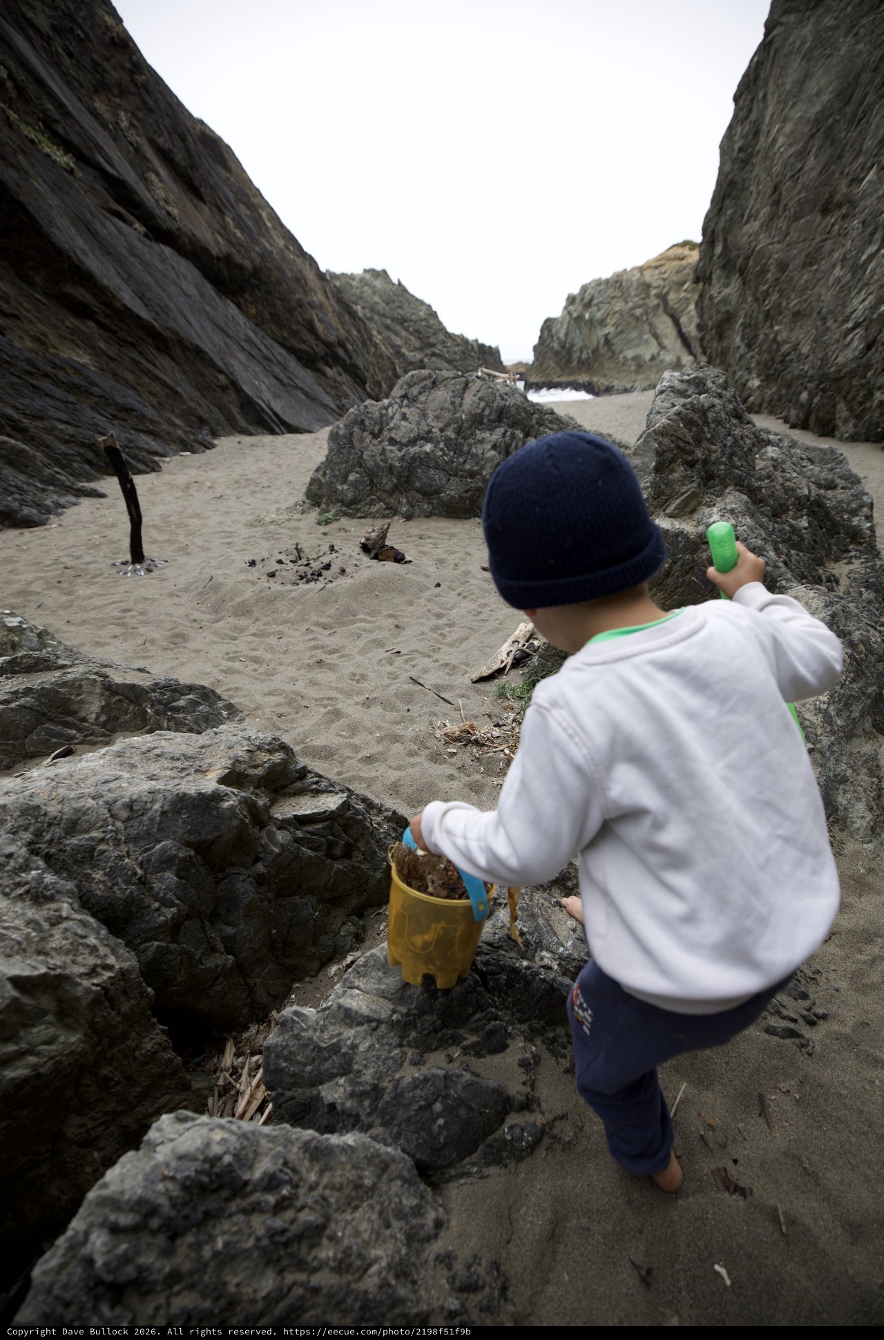 Young Explorer Navigating Rocky Beach Cove Adventure