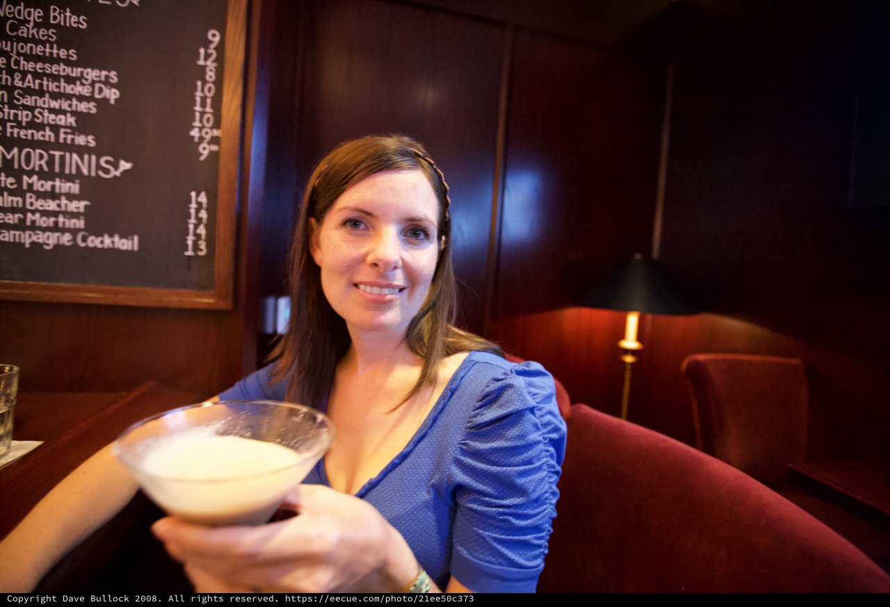 Woman Raising a Creamy Martini at Upscale Bar