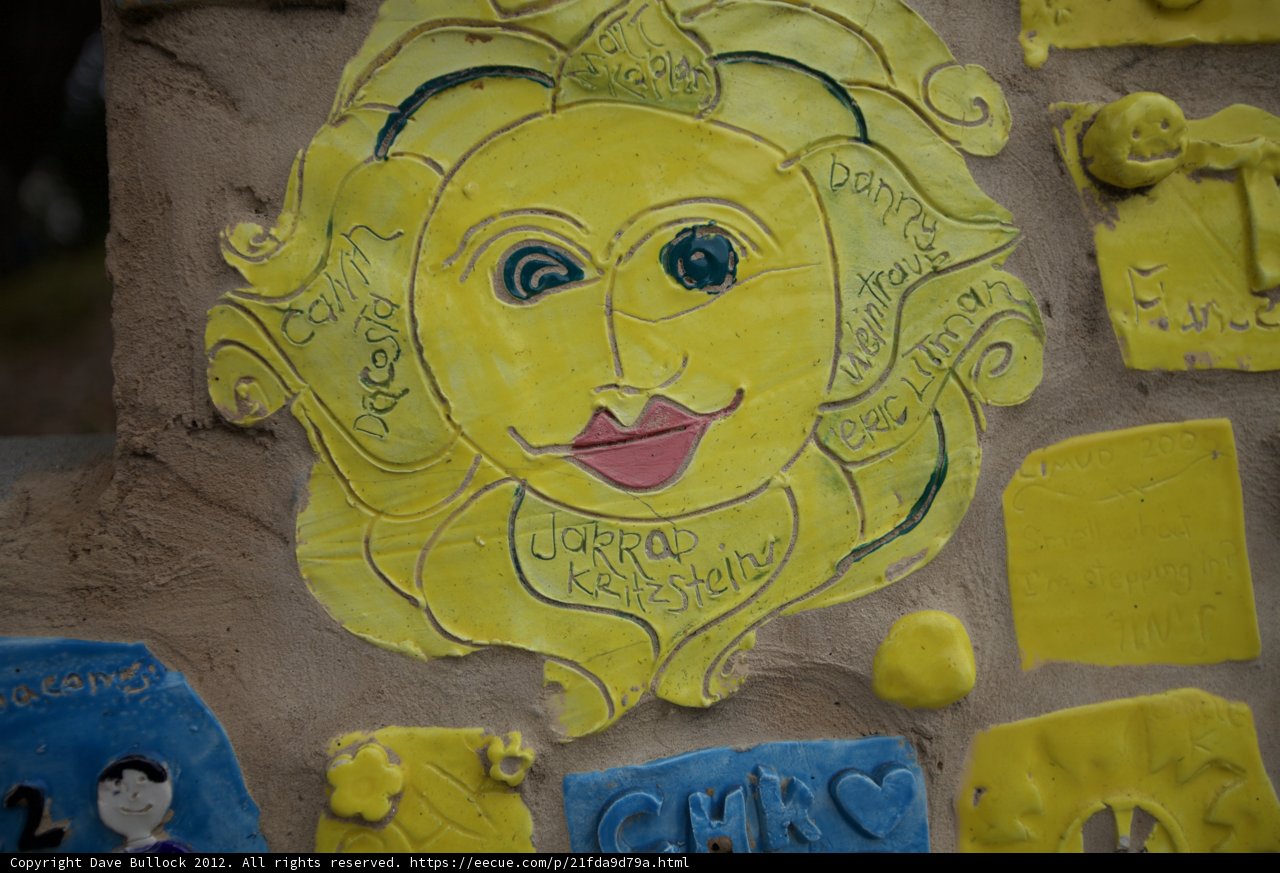 Yellow Sun Face Mural on Building Wall