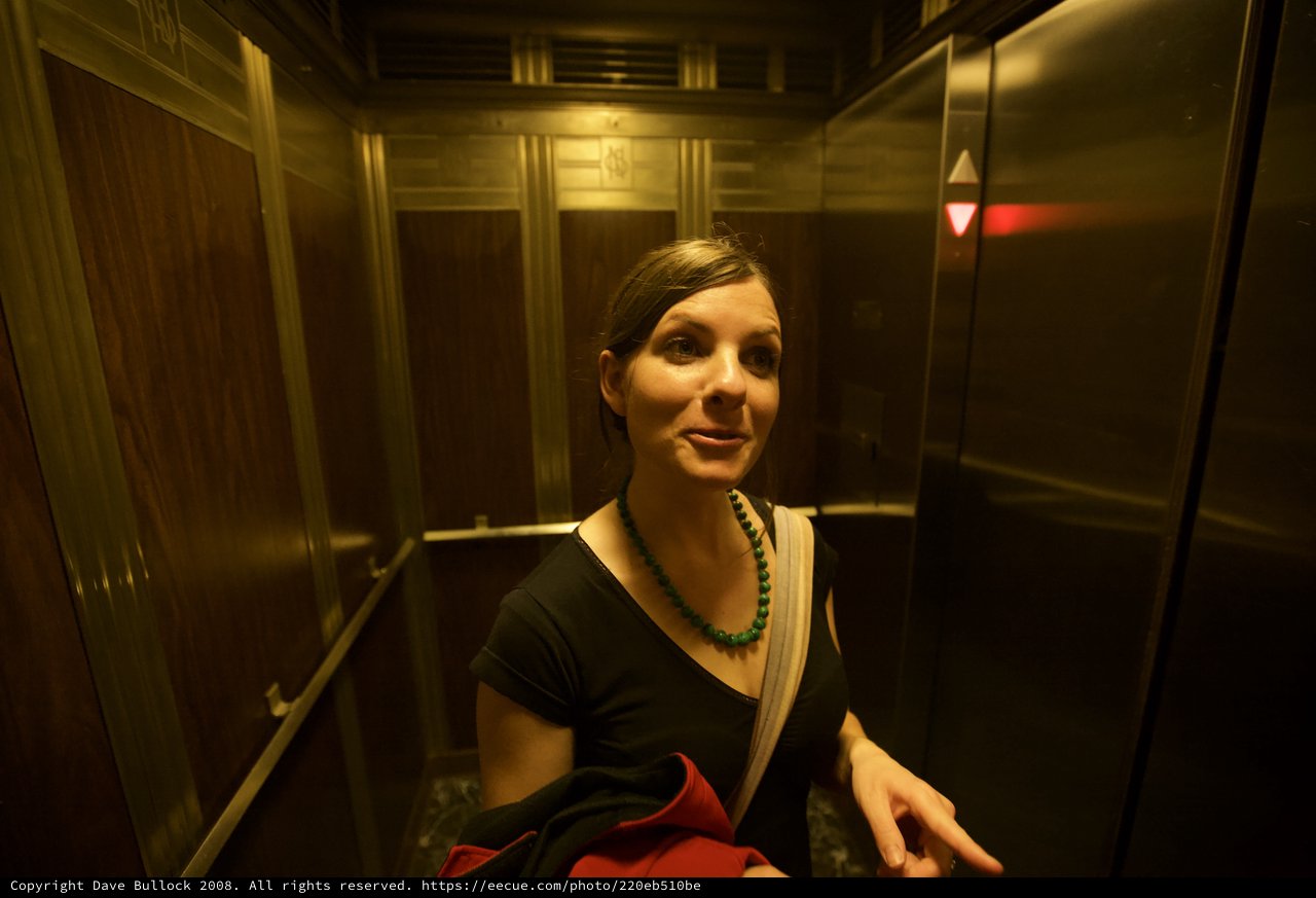 Woman Smiling in Vintage Elevator at Night
