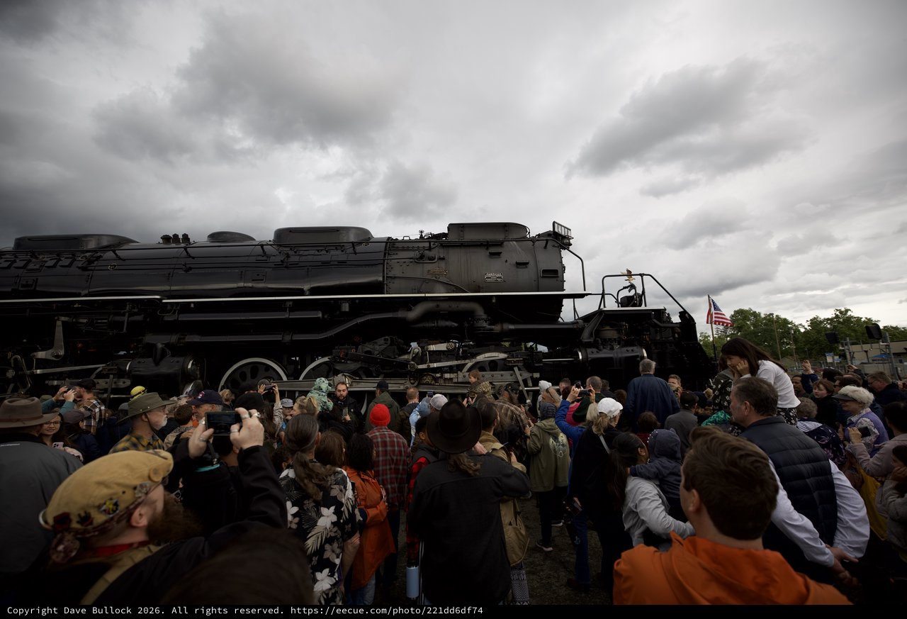 Crowd Gathers Around Historic Steam Locomotive Under Dramatic Sky