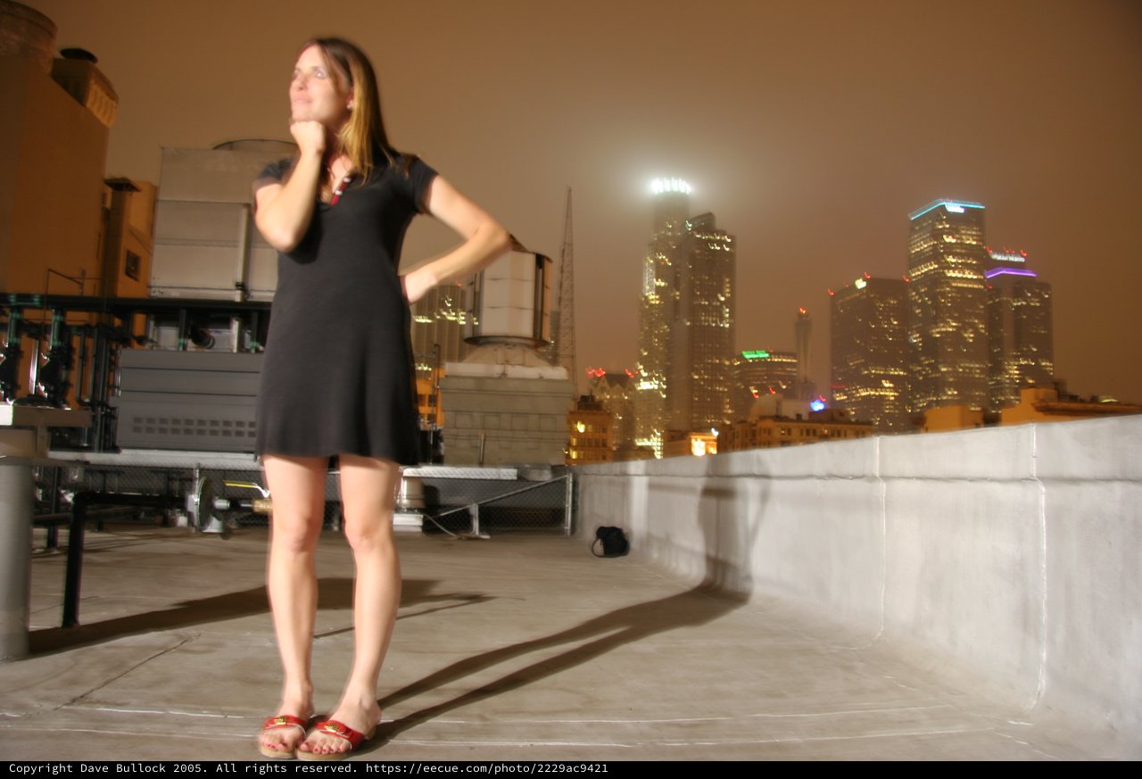 City Lights: Woman Poses on Downtown Rooftop at Night