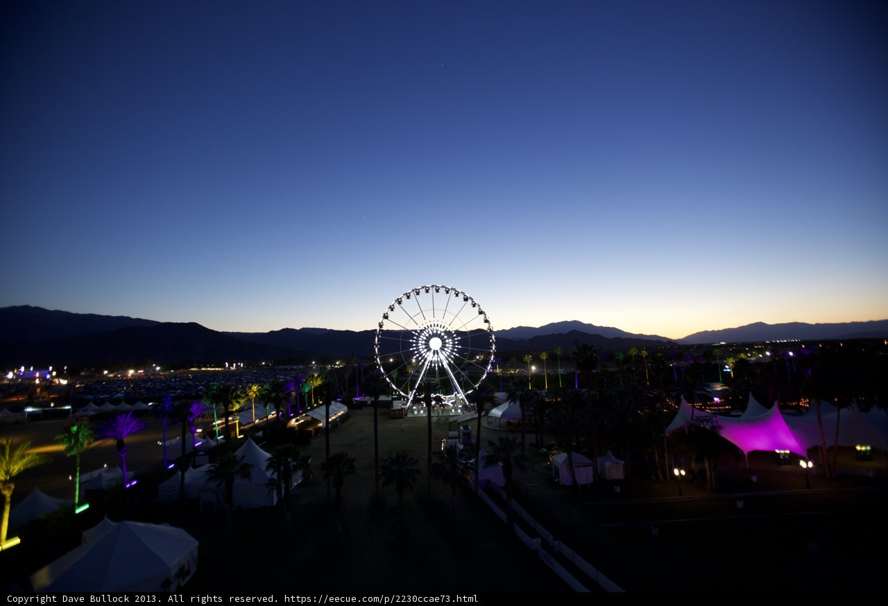 The Glowing Ferris Wheel against Majestic Mountains