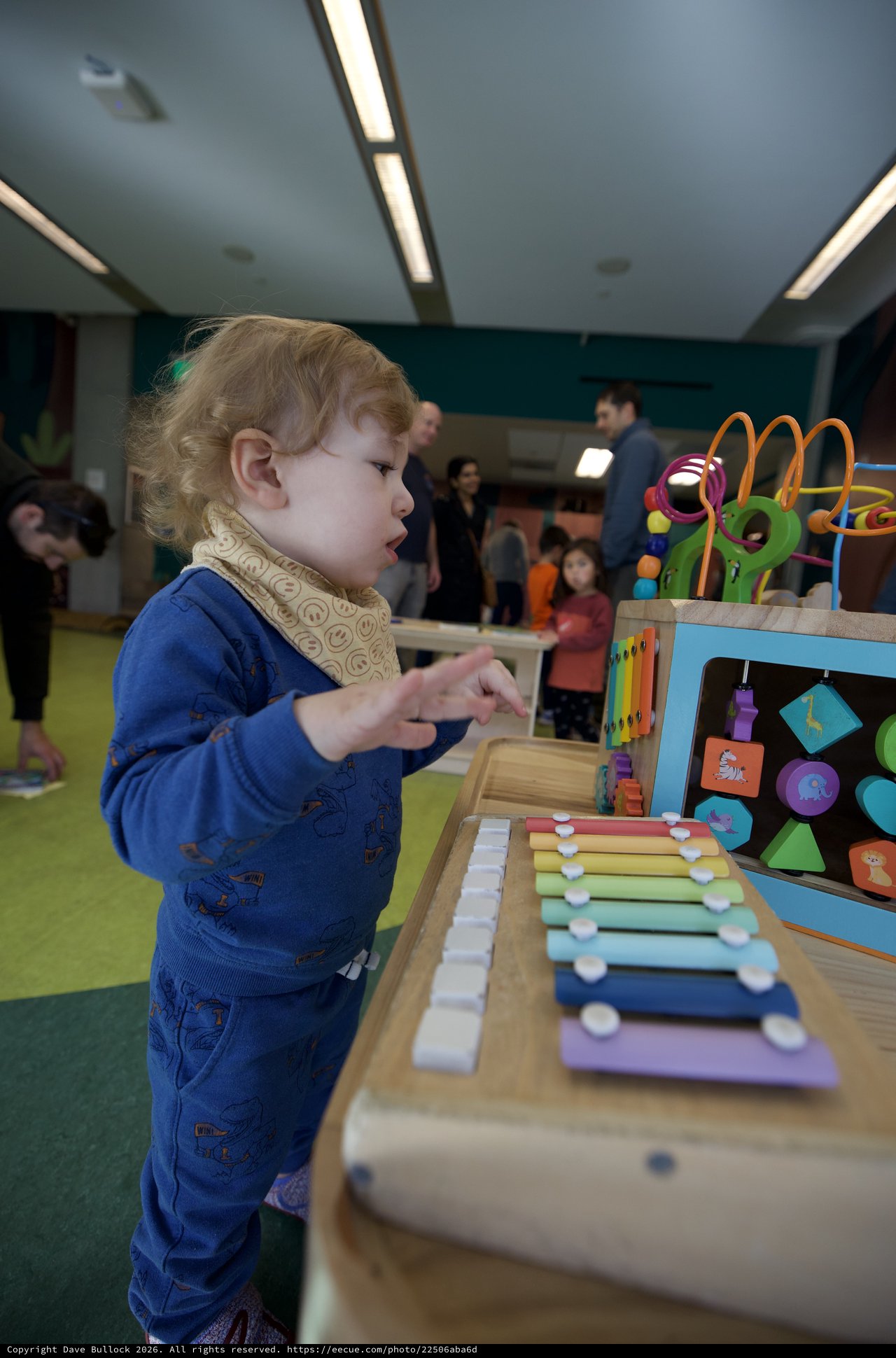 Toddler Exploring Colorful Xylophone at Children's Play Center