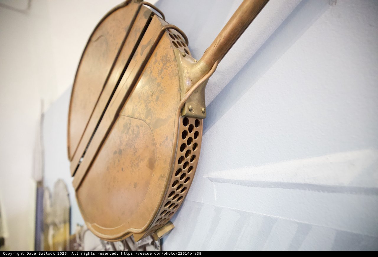 Vintage Brass Bed Warmer Mounted on White Wall