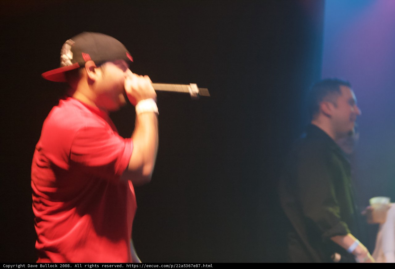 Entertainer Takes the Stage with Microphone and Baseball Cap