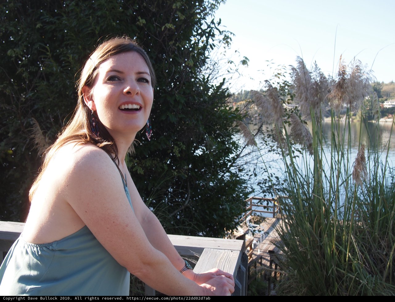Laughing Woman on Waterfront Deck in Autumn Sun