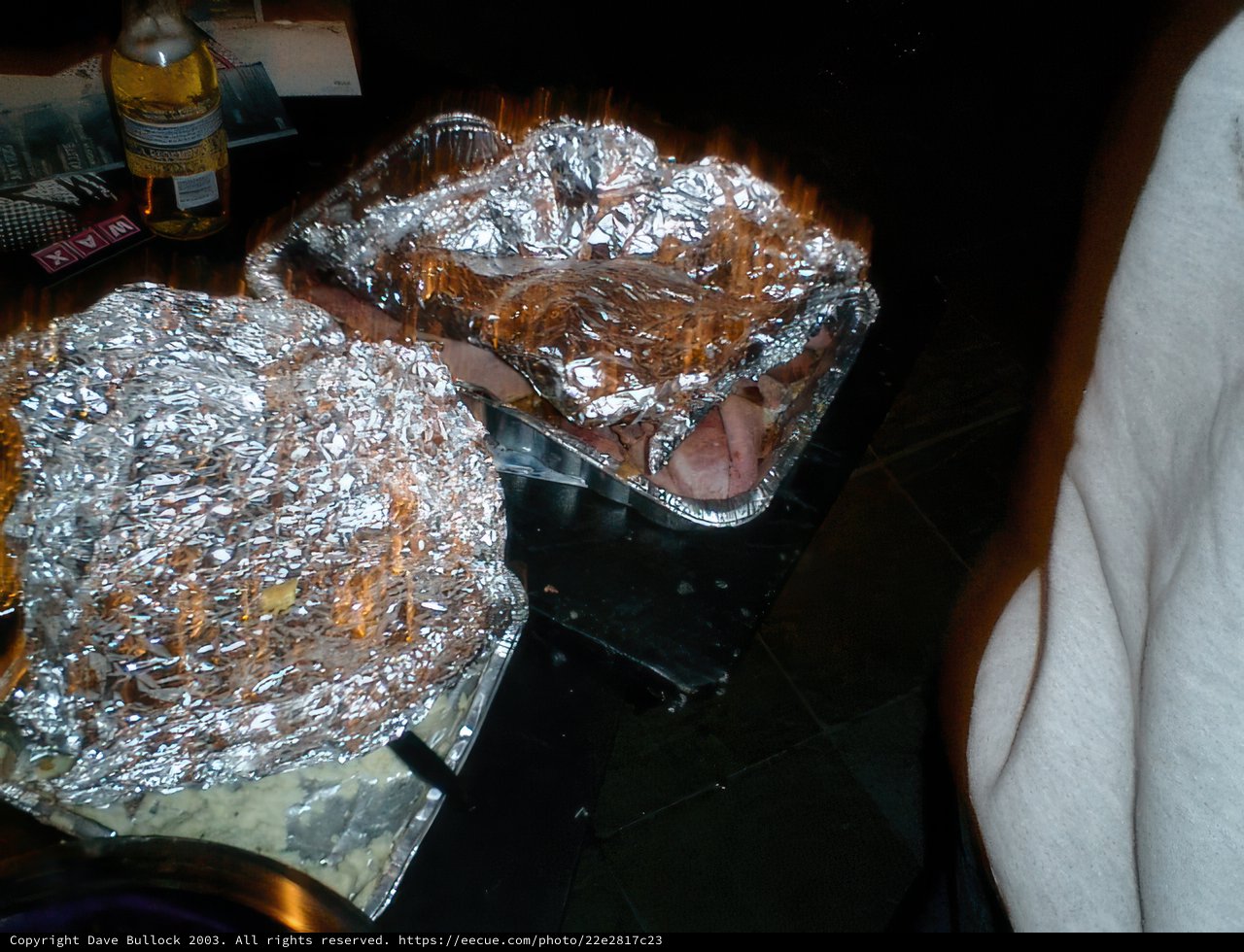 Two Foil Wrapped Trays and a Bottle of Wine