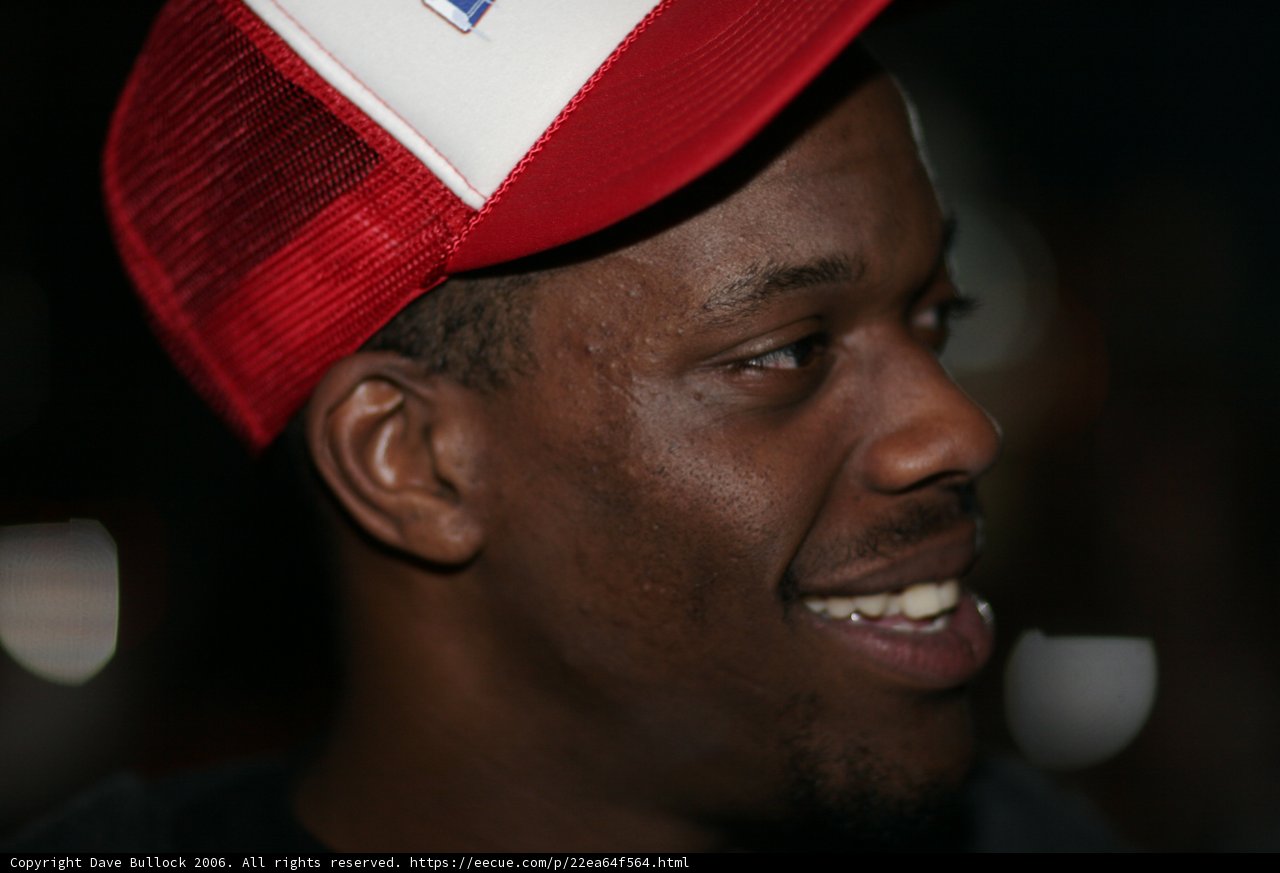 Smiling Man in Red and White Baseball Cap