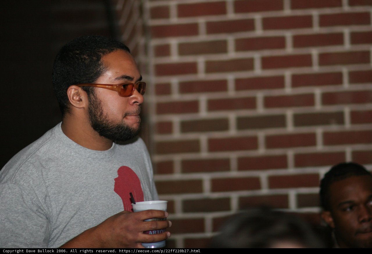 Grey-shirted man with glasses sips coffee