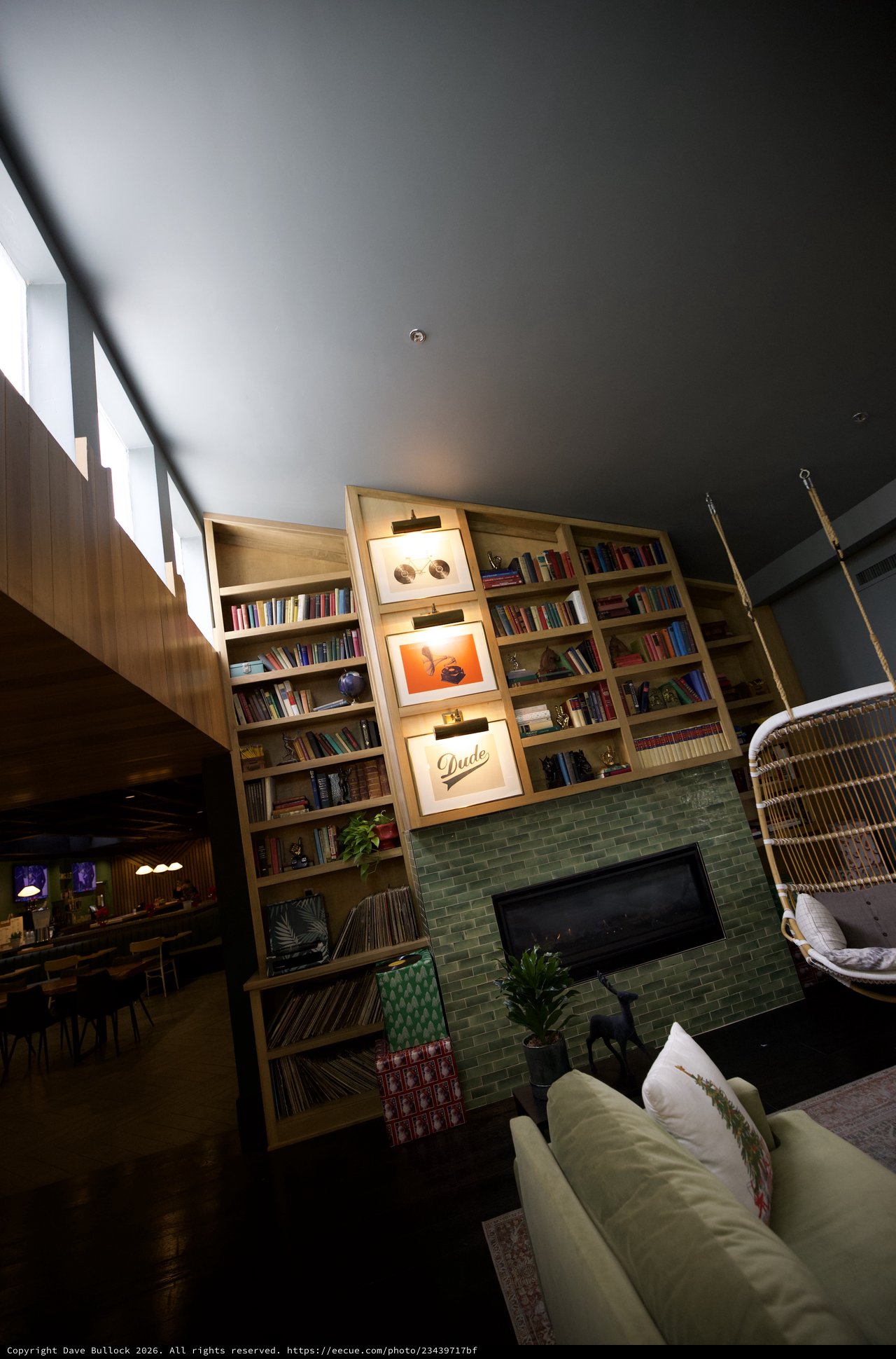 Modern Living Room with Floor-to-Ceiling Bookshelf and Green Fireplace