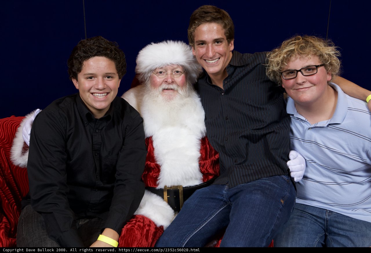 Three Men Strike a Pose with Santa Claus for APC Xmas Party