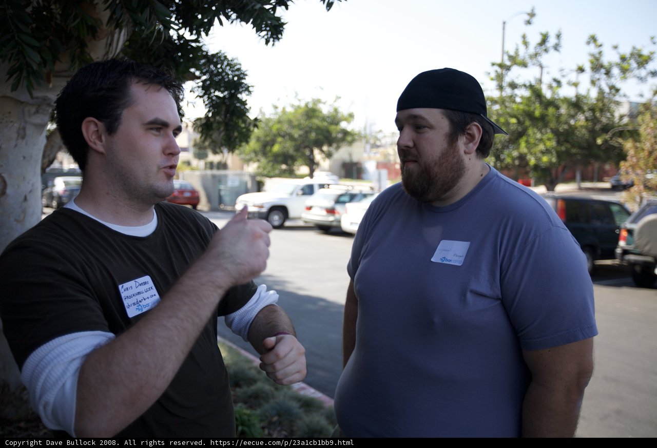 Two Men Chatting by the Cars