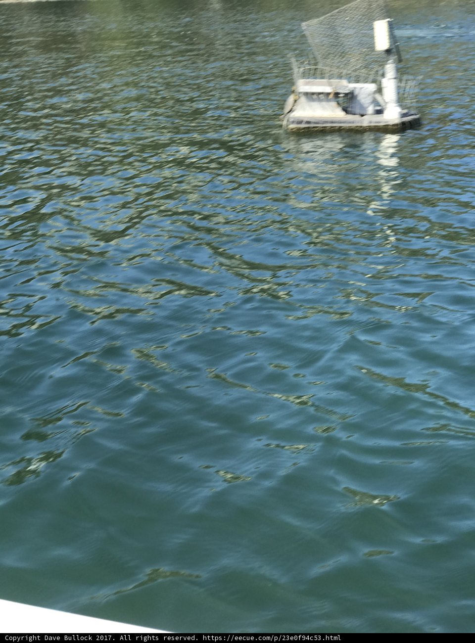 A Sailboat with a Small Boat on Top Sails Through the Waters