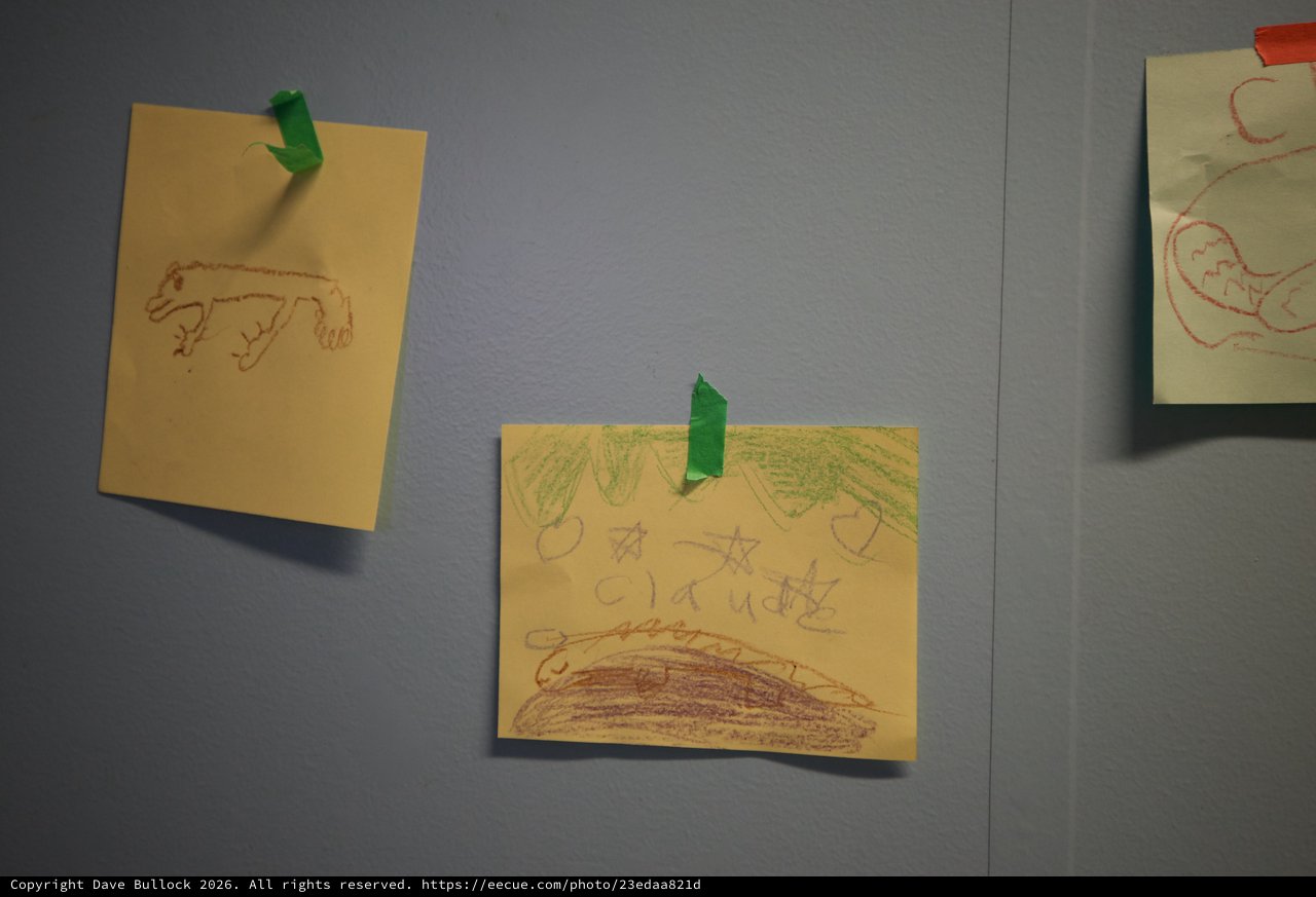 Children's Crayon Drawings Displayed on Gray Wall