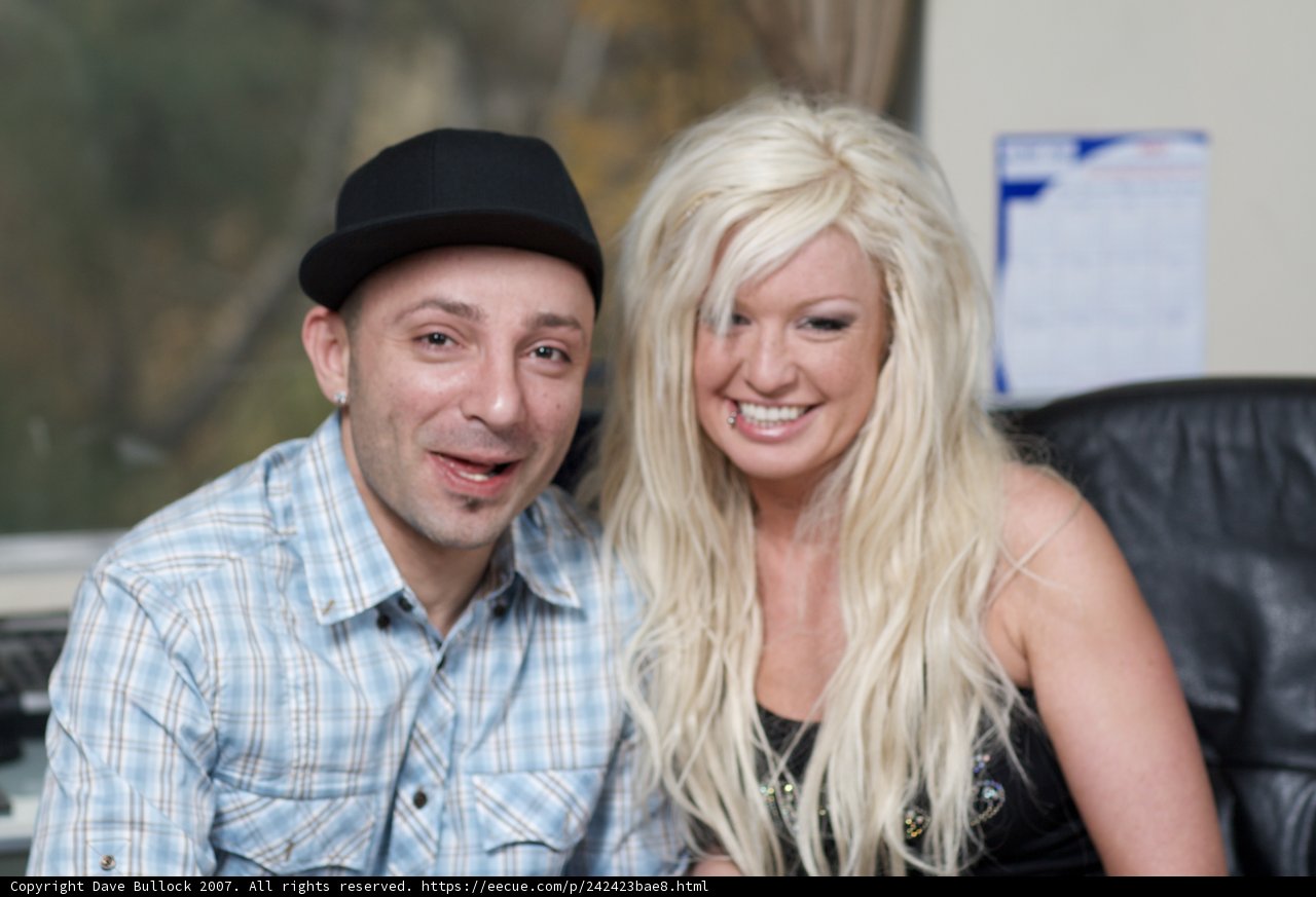 Happy Couple Strikes a Pose in Front of Computer
