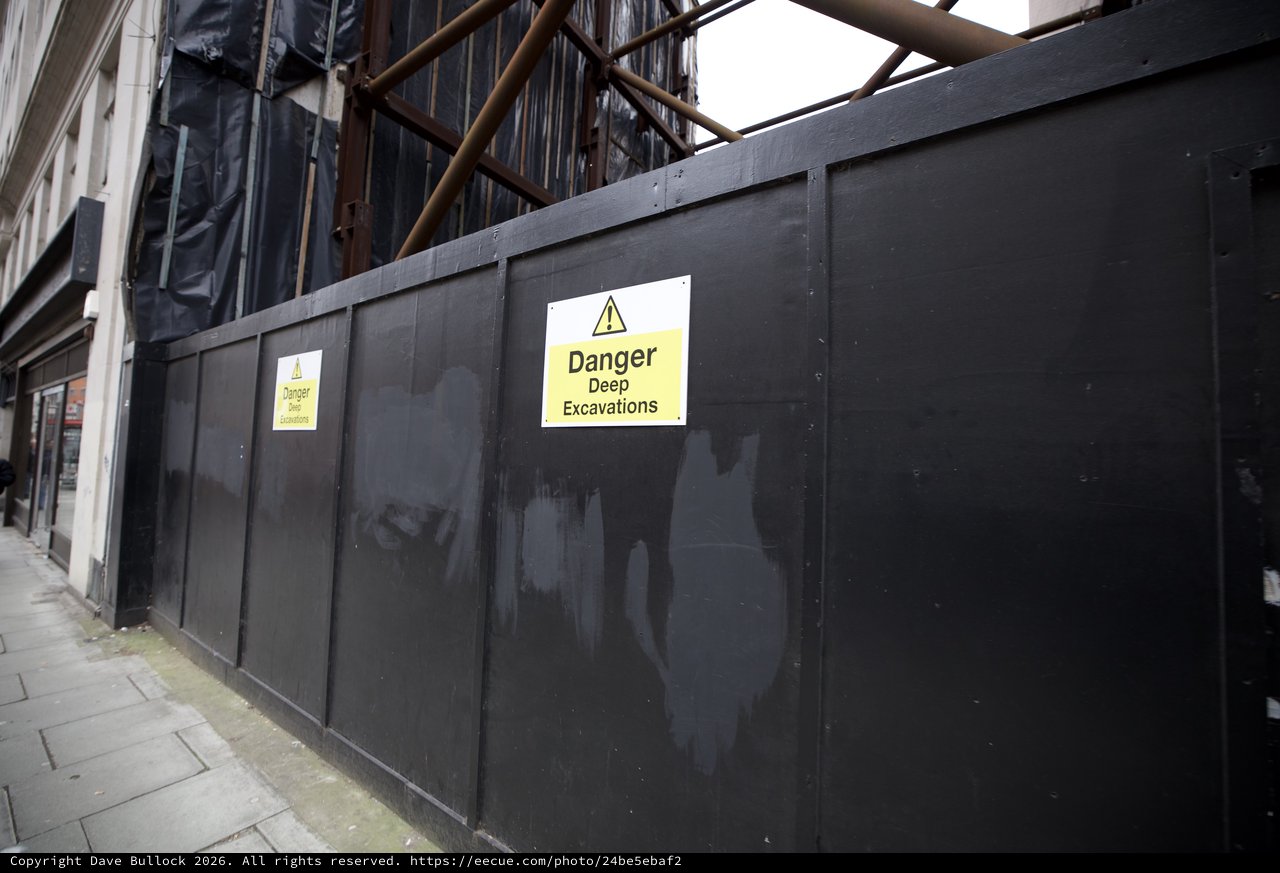 Construction Site Warning Signs on Urban Street Barrier