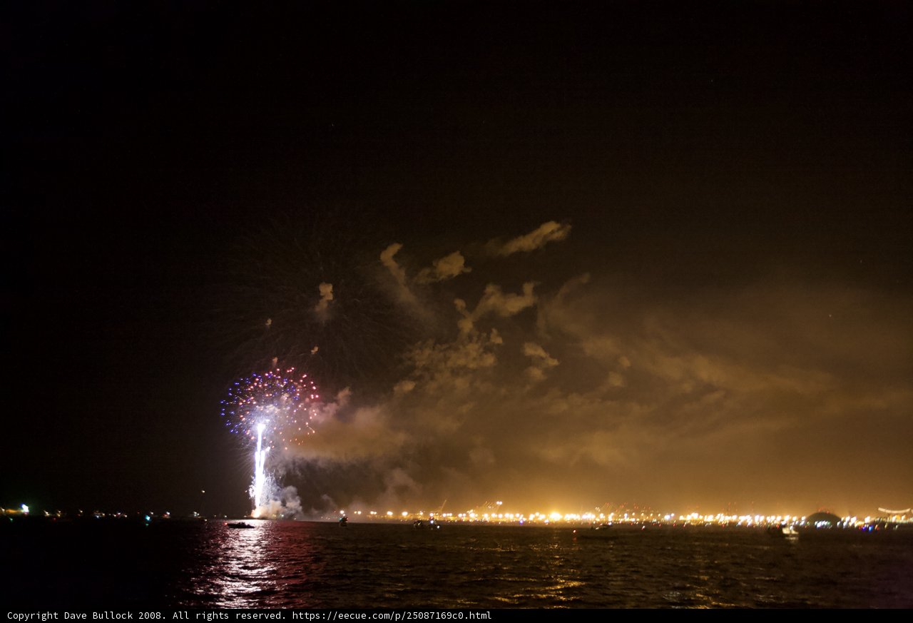 Celebrating Independence Day Caption: A dazzling display of fireworks light up the night sky over the water while the city skyline serves as the perfect backdrop. #fireworks #night sky #outdoor #pyrotechnics #sky #water #4thofJuly
